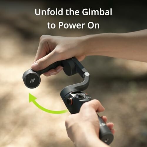 Hands unfolding a gimbal to power on.